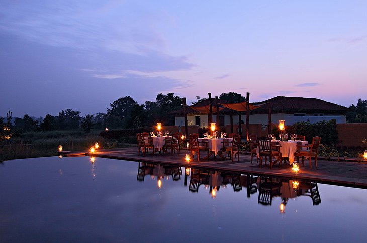 Samode Safari Lodge swimming pool in the evening with dining tables next to it