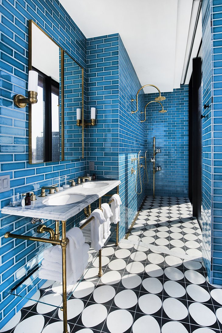 The Williamsburg Hotel bathroom with blue metro tiles and golden faucet