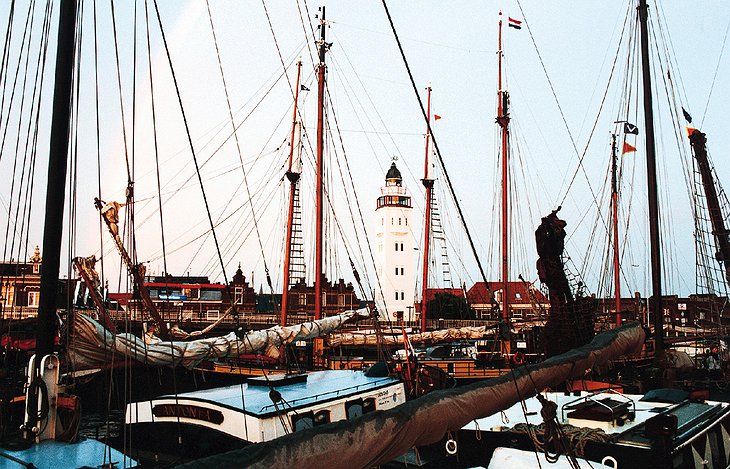 Boats docked and the Harlingen Lighthouse in the background