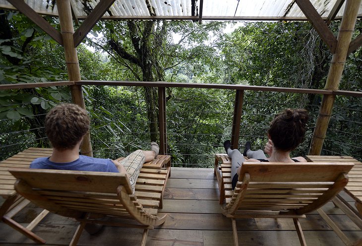 Couple on the treehouse porch overlooking the rainforest