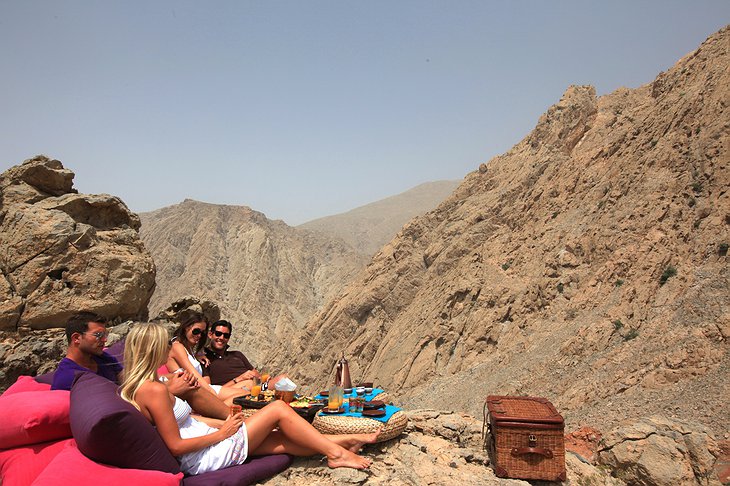 Young people dining on the rocky mountains of Oman