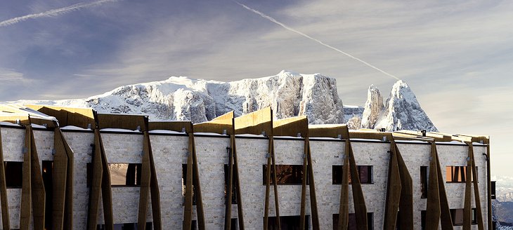 Alpina Dolomites hotel facade with rock formations of the mountains the background