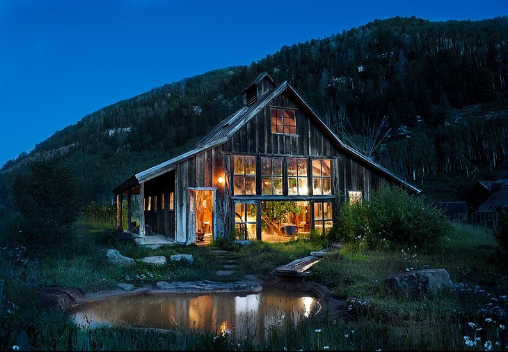 Wood cabin with large windows lit up in the night