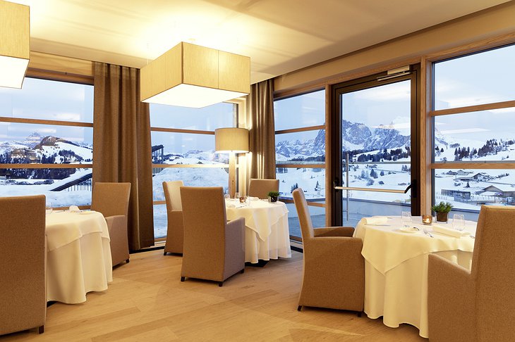 Alpina Dolomites hotel restaurant dining room with panoramic Alpine view