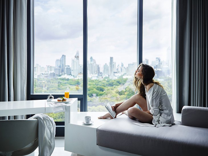 Girl sitting in the window with Bangkok view