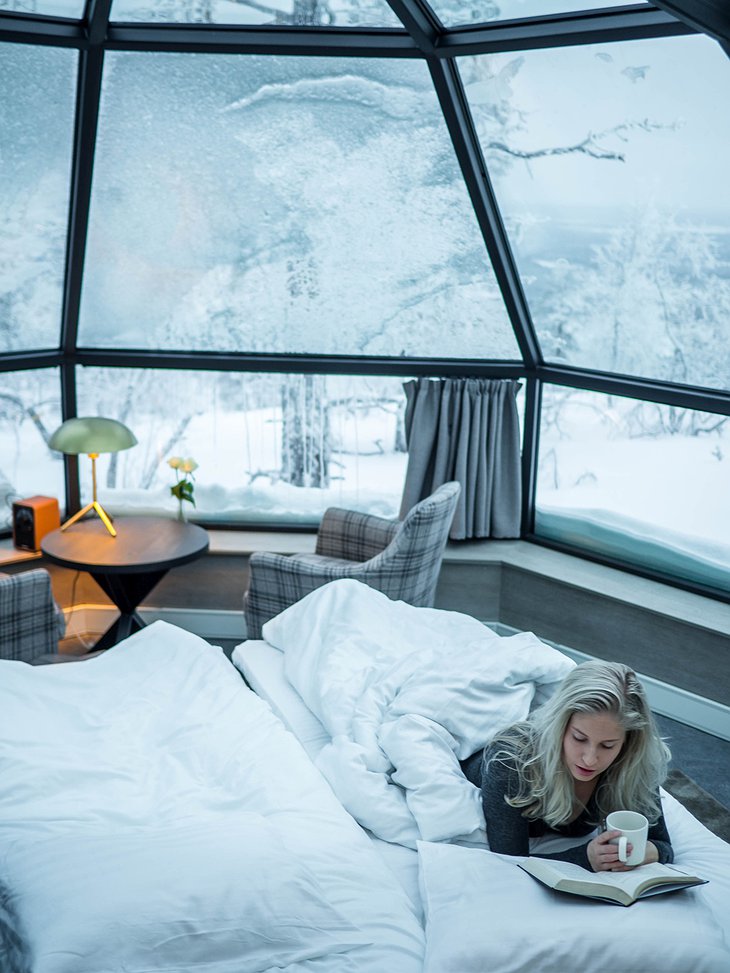 Girl reading in the bed in the igloo with snow outside