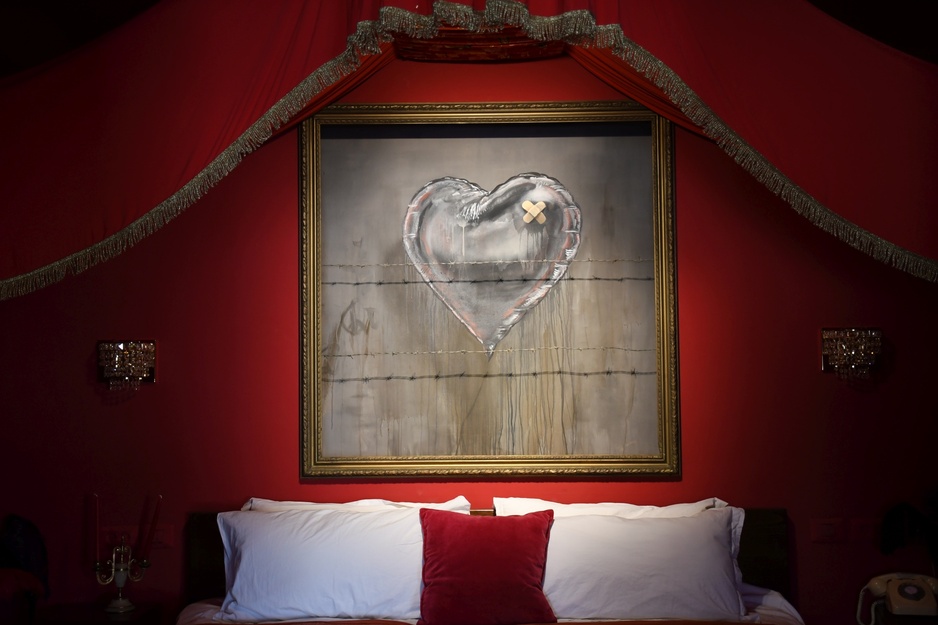 The Walled Off Hotel - Presidential Suite Bed with Love Hurts Banksy Art