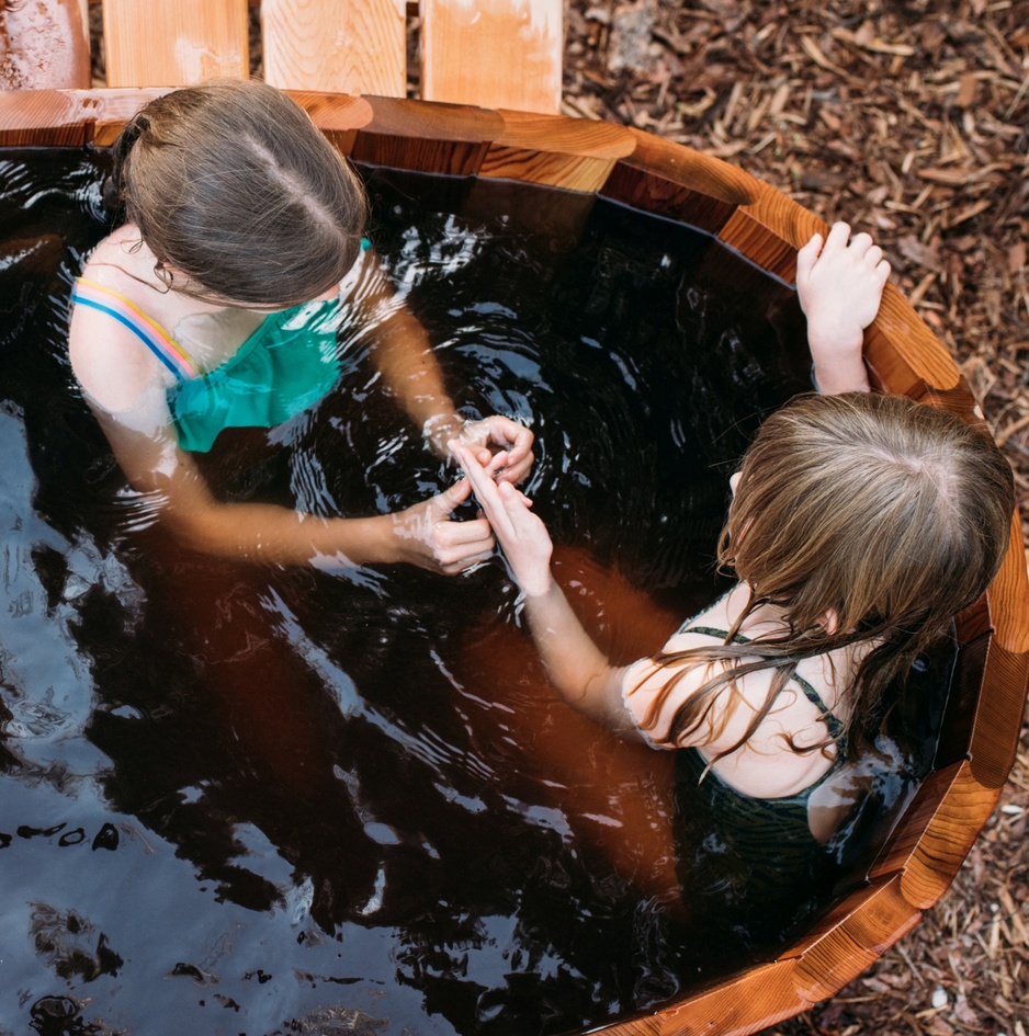 Charmed Resorts Crowsnest Pass Outdoor Hot Tub With Kids Playing