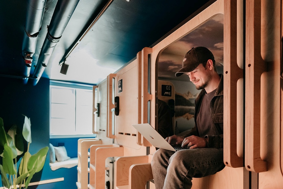 Capsule Hotel Copenhagen Capsule with a Guy Sitting in One