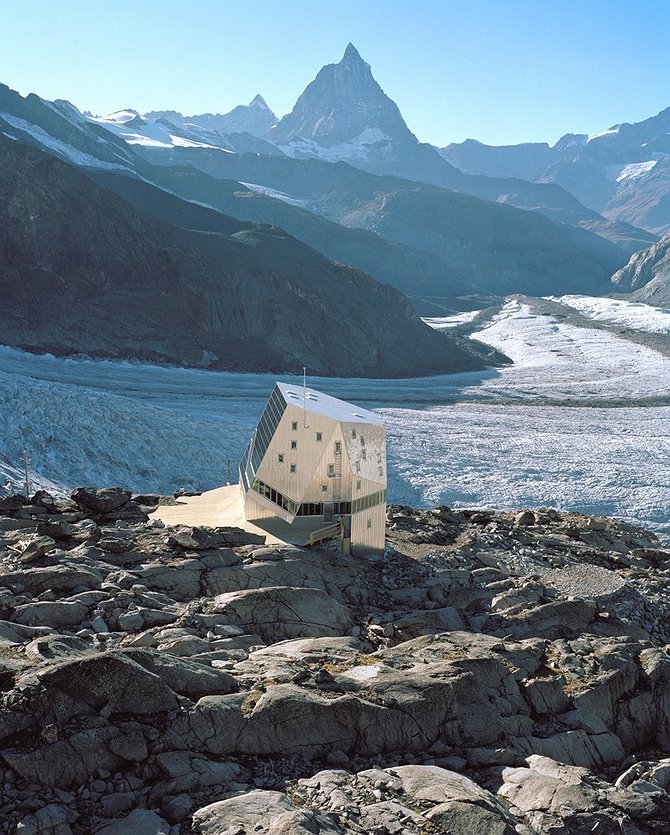 The crystal-shaped exterior of the Monte Rosa Hütte with the pyramid-shaped Matterhorn peak in the background.