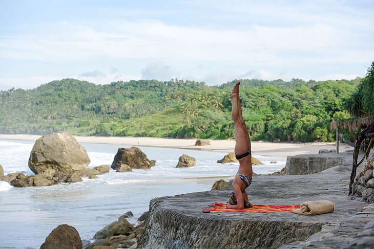 Yoga by the beach on a rock