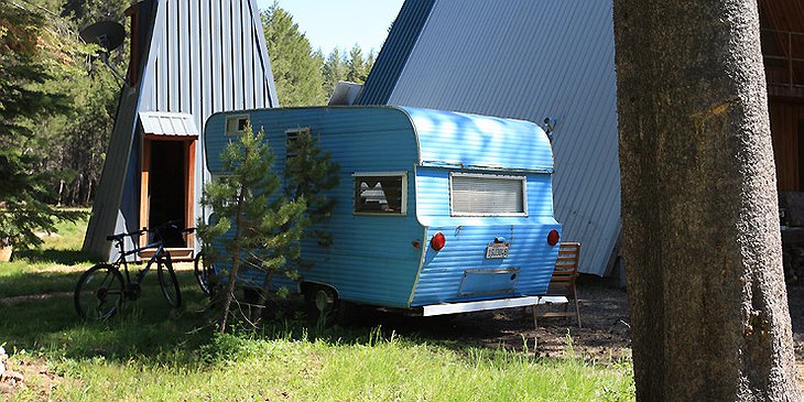 Blue vintage trailer and log cabins