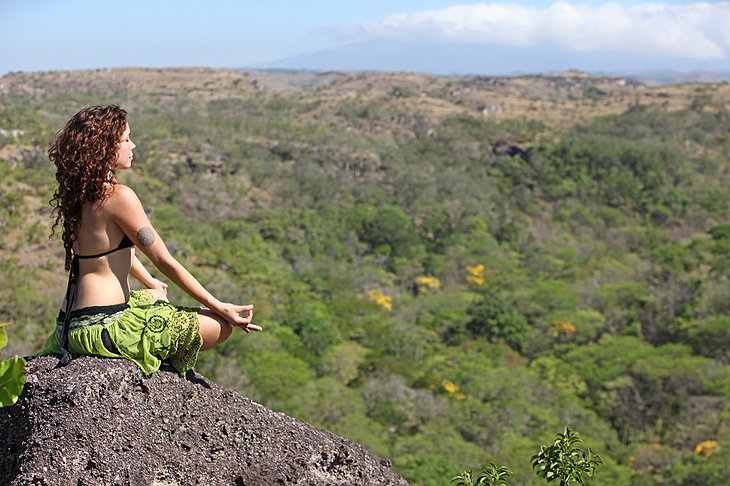 Girl meditating on the rock