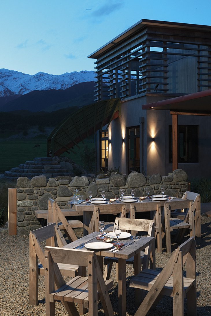 Hapuku Lodge terrace at night with wooden furniture