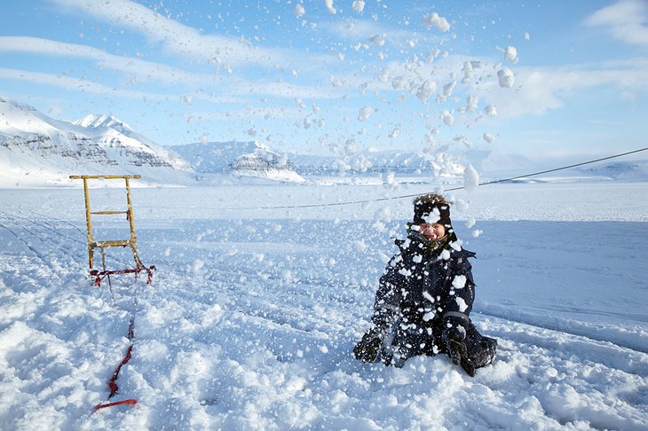 Kid enjoying the sledging on the ice of the fjord