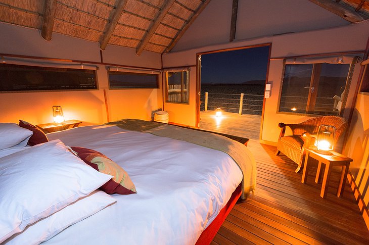 Kulala Desert Lodge room at night with open door to balcony