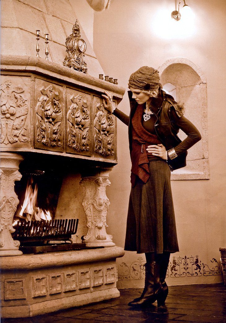 Stylish woman standing at the fireplace