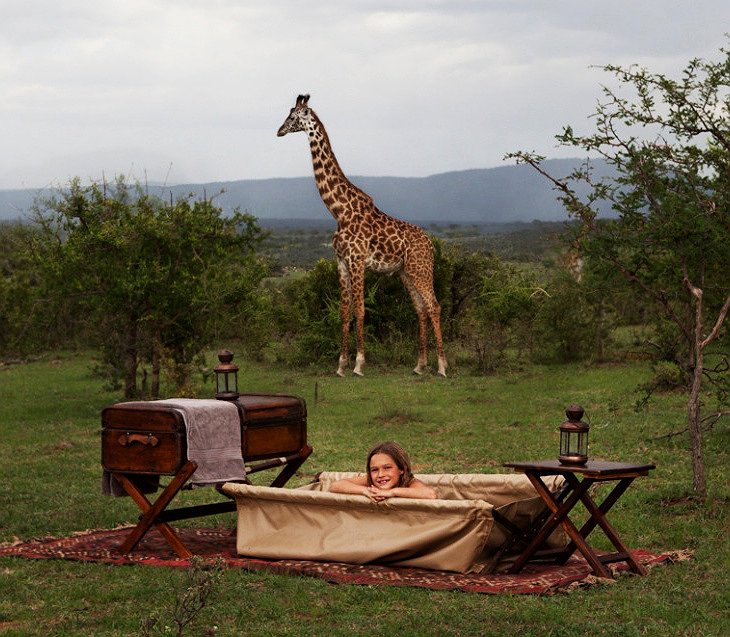 Ella Cottar in bath with giraffe in background