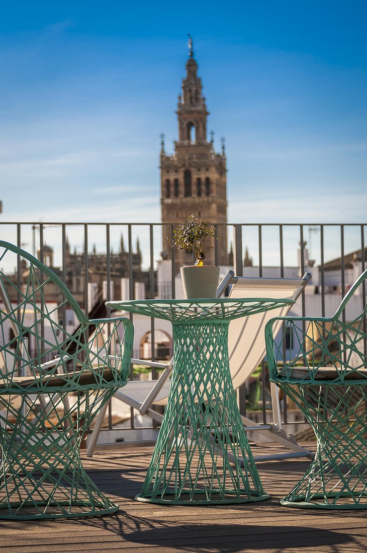 Hotel Amadeus Seville rooftop terrace green design chairs and the Cathedral in the background