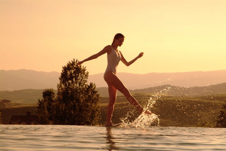 Beautiful woman in white bikini kicking the water